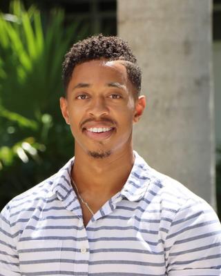 A person smiling standing outside