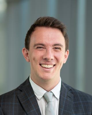 a person smiling wearing a suit