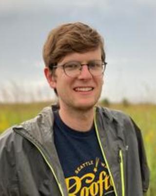 Professional headshot of person standing outside