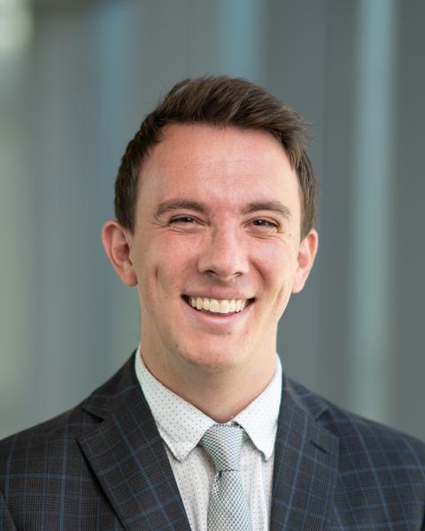 a person smiling wearing a suit