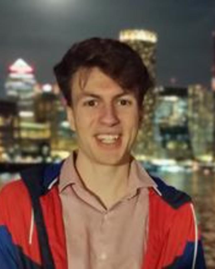 Professional headshot of a person standing outside at night